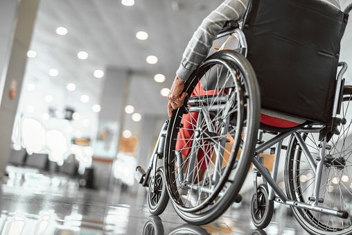 Señora de edad avanzada está usando una silla de ruedas en el aeropuerto photo