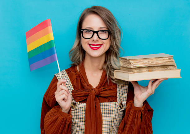 Young woman with books and LGBT flag stock photo