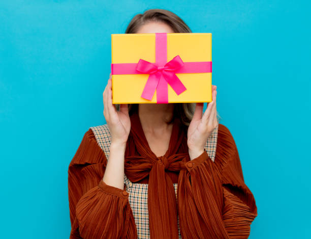 istock Young  woman with yellow gift box 1157446003