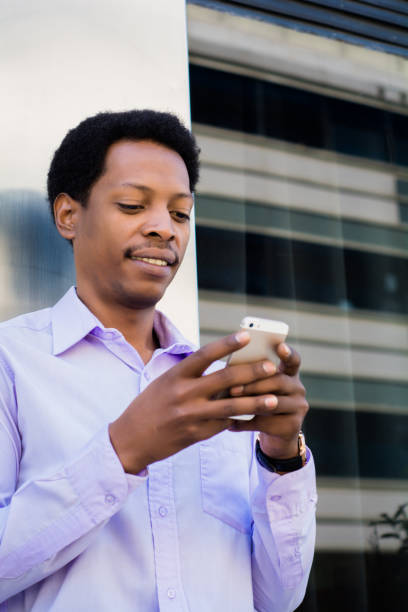 istock Latin businessman using mobile phone in the city. 1157446187