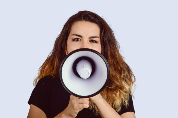 istock Young woman screaming on a megaphone 1157446218