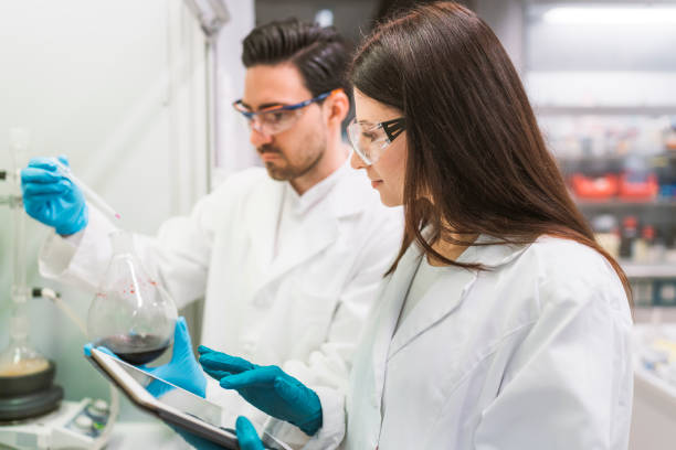 istock Woman scientist looking at measurements on a tablet, working in laboratory 1157447727