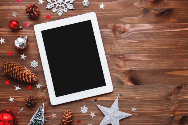 Christmas and New Year background with tablet and decorations. Place for text. Mock up, flat lay, top view.