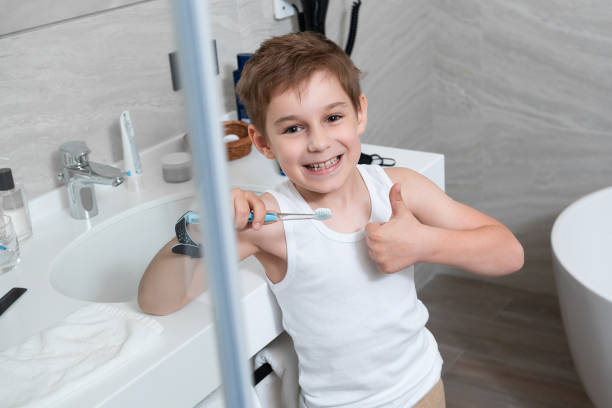 le petit garçon se tient dans la salle de bains - brushing teeth photos et images de collection