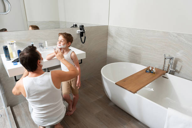 papá e hijo están de pie en el baño y afeitándose juntos - shaving equipment wash bowl bathroom razor fotografías e imágenes de stock