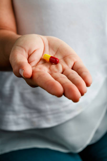 istock Single pill on young woman hands 1157454178