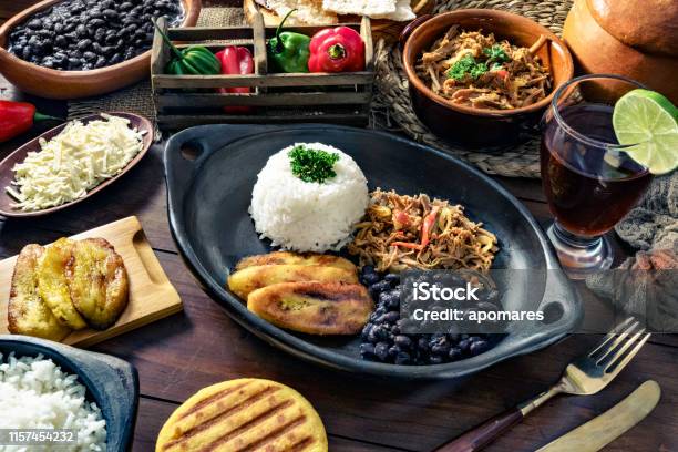 Venezuelan Traditional Food Pabellon Criollo With Arepas Casabe And Papelon With Lemon Drink Stock Photo - Download Image Now