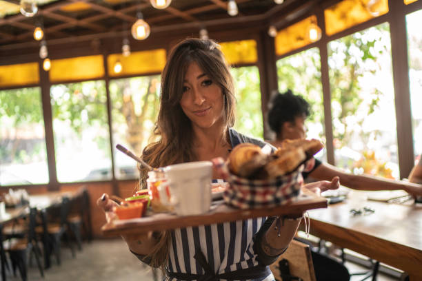 istock Happy waitress serving tray with food, portrait 1157457294