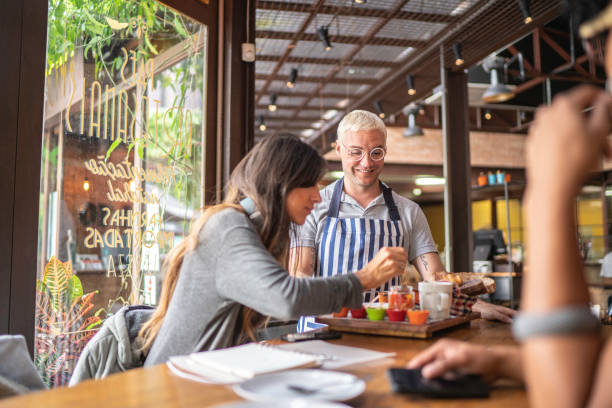 istock Waiter serving food to customers in a restaurant 1157457313
