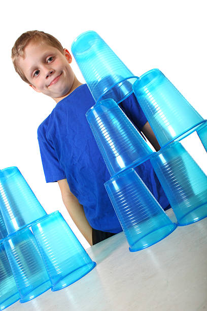 rapaz olhando para empilhados cups - cup child geometric shape stacking imagens e fotografias de stock