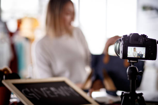 istock Woman filming a video blog using DSLR camera 1157458906