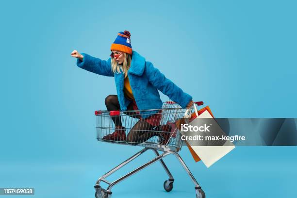 Young Woman With Shopping Bags Riding Trolley Stock Photo - Download Image Now - Retail, Shopping Cart, Women