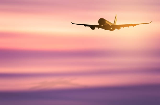 istock Airplane flying over blur tropical beach and sunset sky abstract background. Copy space of business summer vacation and travel adventure concept. Vintage tone filter effect color style. 1157475196