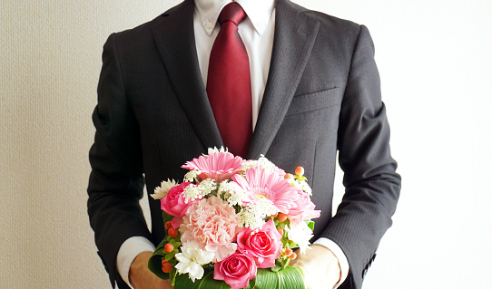 Businessman giving a pink bouquet.