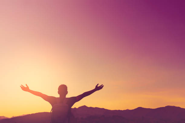 istock Backpacker man raise hand up on top of mountain with sunset sky and clouds abstract background. Copy space freedom travel adventure and feel good concept. Vintage tone filter effect color style. 1157476103