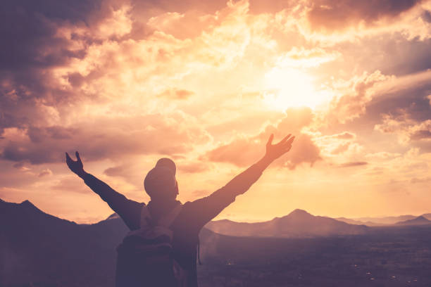 istock Backpacker man raise hand up on top of mountain with sunset sky and clouds abstract background. Copy space freedom travel adventure and feel good concept. Vintage tone filter effect color style. 1157476105