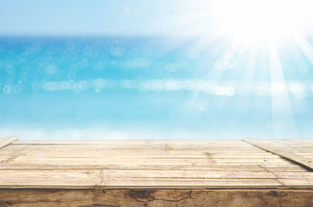 istock Blur tropical beach with bokeh sun light wave on empty old nature wood table abstract background. Product presentation in nature. Vintage tone filter color style. 1157477183