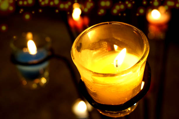 istock Small glass candle in darkness 1157478465