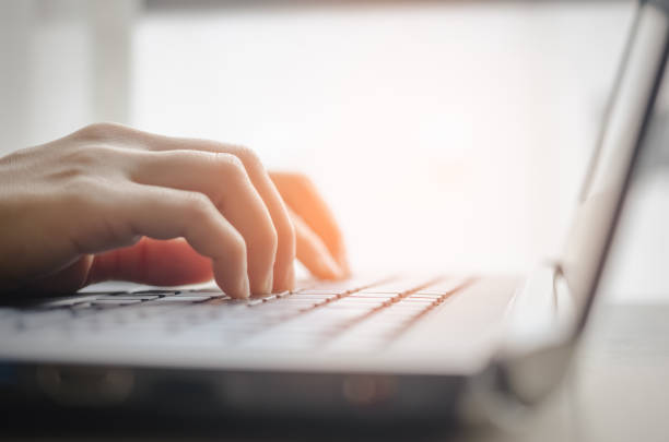 istock Close up woman hand using keyboard and notebook. Technology and business concept. Shallow depth of field. Vintage tone filter color style. 1157479396