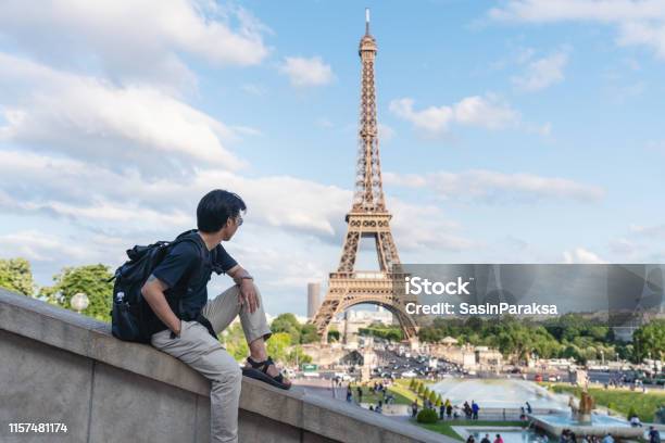 A Man With Backpack Looking At Eiffel Tower Famous Landmark And Travel Destination In Paris France Traveling In Europe In Summer Stock Photo - Download Image Now