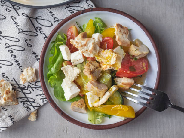 istock Light breakfast from Caesar salad on two tarekkas, standing on a cotton napkin with a pattern, fork, filmed from a high angle from close range 1157481223