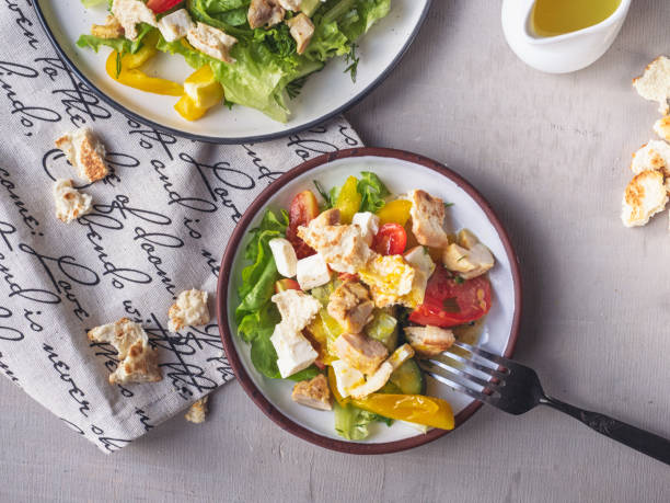 istock Light breakfast from Caesar salad on two tarekkas, standing on a cotton napkin with a pattern, cutlery and sauceboat with salad dressing, cutlery 1157481237