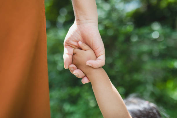 madre e figlia che si tengono le mani l'una dell'altra nel parco - holding hands human hand child mother foto e immagini stock