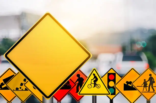 Empty yellow and set of traffic sign on blur traffic road with colorful bokeh city light abstract background. Copy space of transportation and travel concept. Retro tone filter effect color style.