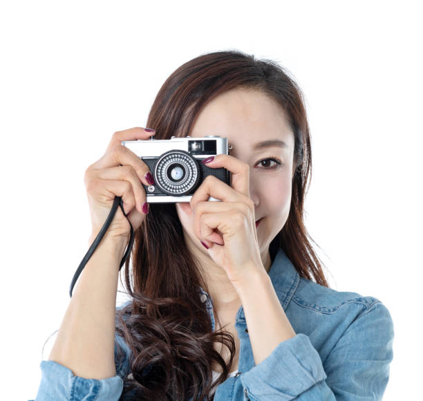 istock Beautiful woman holding an old camera on white background 1157485611