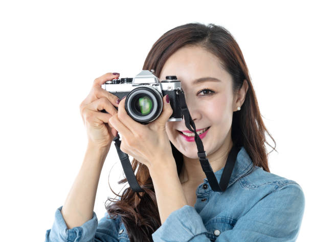 istock Beautiful woman holding a SLR camera on white background 1157485631
