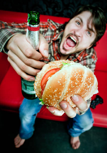Angry coach potato Young couch potato with burger, beer and videogame joystick brat burger stock pictures, royalty-free photos & images