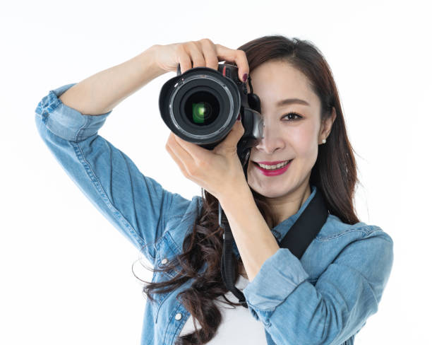 istock Woman holding professional digital camera on white background 1157486313