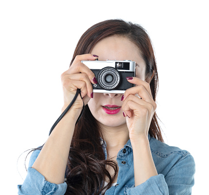 Beautiful woman holding an old camera on white background.