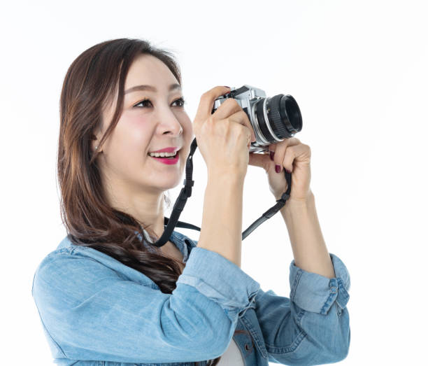 istock Beautiful woman holding a SLR camera on white background 1157486510
