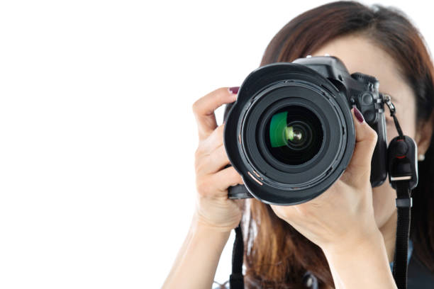 Woman holding professional digital camera on white background.