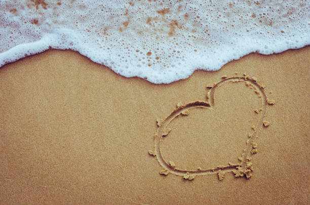 istock Heart drawing on sand beach with smooth wave texture abstract background. Copy space of love freedom and travel relax concept. Retro color tone filter effect color style. 1157487831