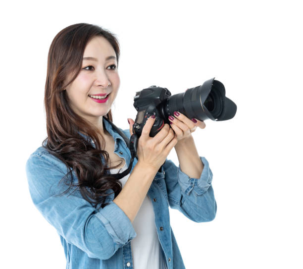 istock Woman holding professional digital camera on white background 1157490470