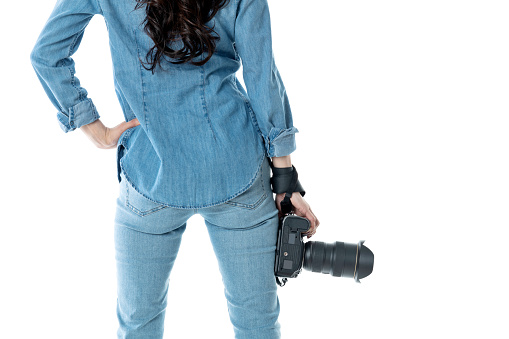 Woman hand holding a SLR camera on white background.