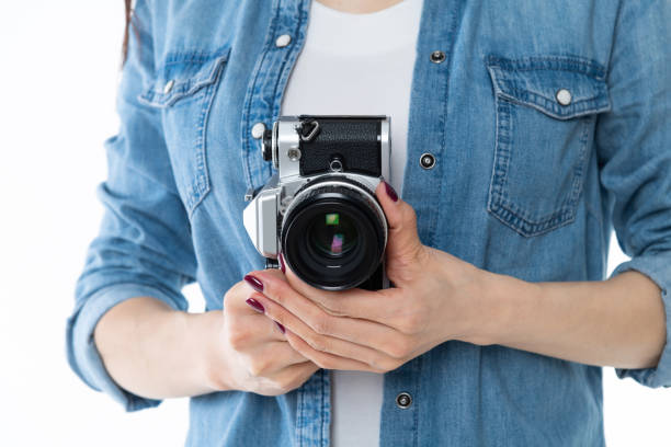 istock Woman hand holding a SLR camera on white background 1157491551