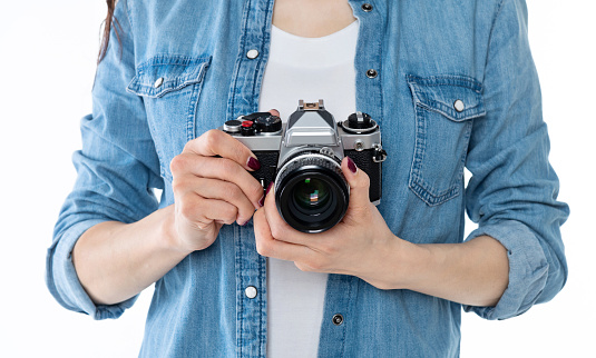 Woman hand holding a SLR camera on white background.