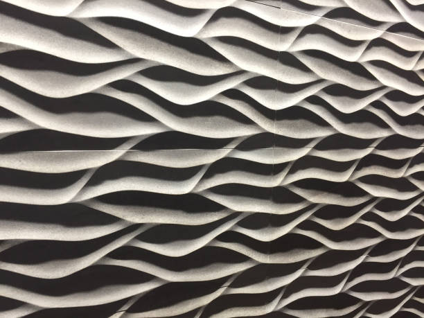 istock Image of modern black and white textured wall background with curved and raised interlocked panels lit to create shadows, contemporary interior design wallpaper background with curvy lines against feature wall in architect designed home 1157497111