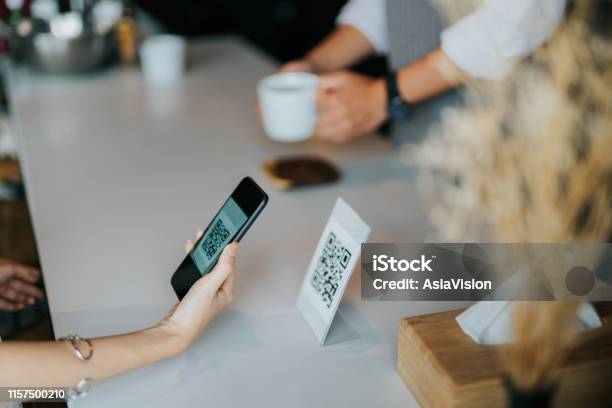 Womans Hand Holding Smartphone Scanning Barcode For Contactless Payment In The Cafe Stock Photo - Download Image Now