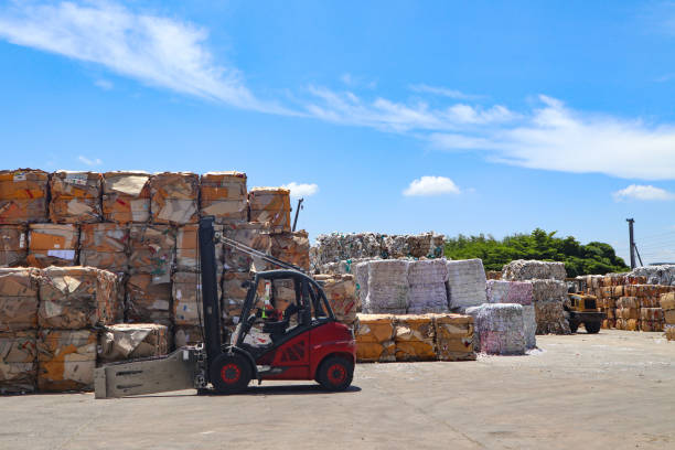 Bangkok/Thailand-June 22,2019: Thai recycle industry cardboard garbage and paper waste after pressing in hydraulic baling garbage press machine to a square dense for transportation to recycle factory bangkok/tailandia-22 de junio de 2019: la industria tailandesa recicla residuos de basura y papel de cartón de la industria después de presionar en la máquina de prensadería hidráulica de enfardado a un cuadrado denso para el transporte a la fábrica