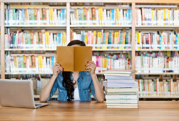 도서관에서 책 뒤에 숨어있는 여자 - bookstore student chinese ethnicity book 뉴스 사진 이미지