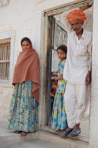 Sar, India - December 13, 2009: Indian Rural senior family men and daughter standing infront of village house and happy to posing photography in village sar, Rajasthan-India