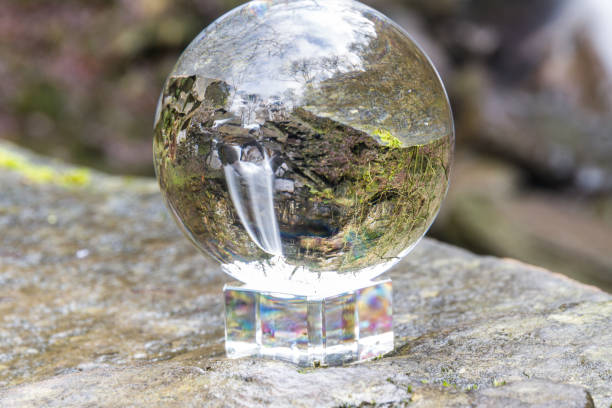 istock Water cascading down beautiful waterfall, Melincourt, through crystal ball 1157504478