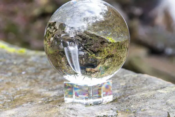 Photo of Water cascading down beautiful waterfall, Melincourt, through crystal ball