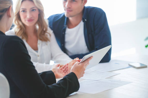 Real estate agent with couple looking through documents