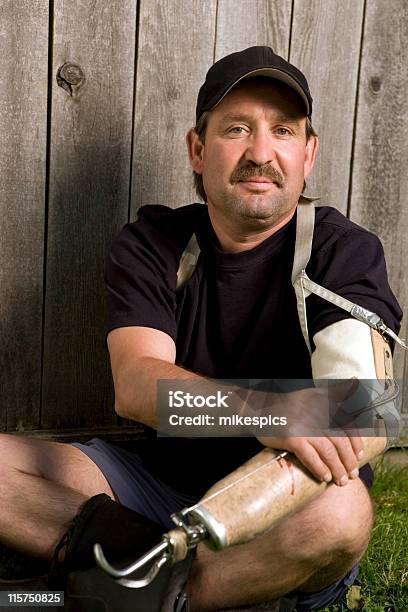 Man With Prosthetic Arm Sitting On Lawn Stock Photo - Download Image Now - Men, Prosthetic Equipment, Accidents and Disasters