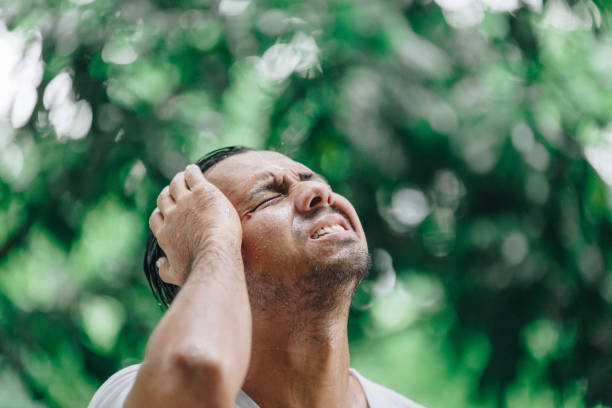 istock Sad young Asian man standing outdoors during rain 1157508515